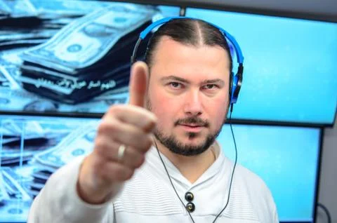 Video broadcast editor with headphones watching an action on the monitor. L.. Stock Photos