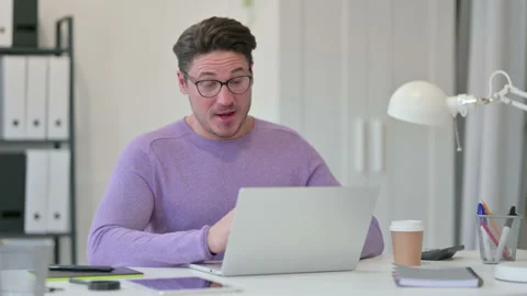 Video Call on Laptop by Creative Middle Aged Man in Office Stock Footage 143565851