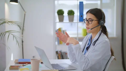 Video Calling Distant Patient on Laptop. Doctor Talking to Client in Home Office Stock Footage 143156344