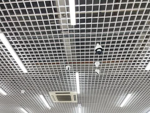Video camera on the ceiling in a modern building. Video surveillance. Stock Photos
