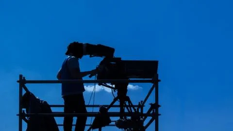 Video camera operator - man working and filming on set with his equipment Stock Photos