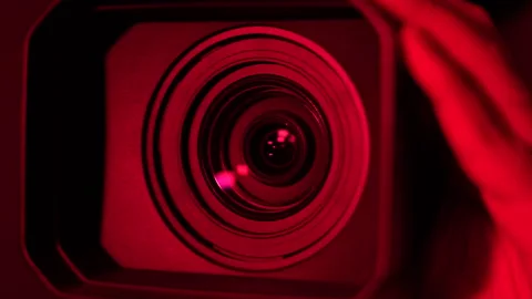 The video camera shoots from bottom to top in red light Stock Footage 276115651