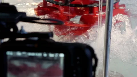 A video camera on a tripod records the rotation of the hydraulic turbine. Stock Footage 161223217