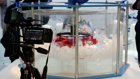 A video camera on a tripod records the rotation of the hydraulic turbine. Stock Footage 161223692