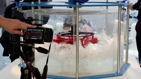A video camera on a tripod records the rotation of the hydraulic turbine. Stock Footage 162268975