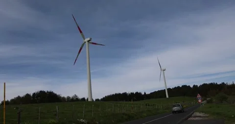A video capturing the motion of wind turbines spinning on a hill Stock Footage 316832942