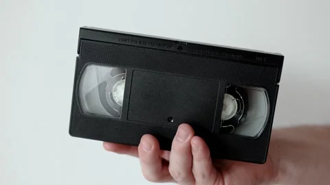 Video cassette in hand.	 Stock Footage 301557129