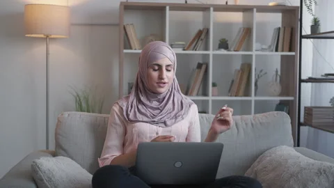 Video chat internet call laptop woman couch home Stock Footage 194557739