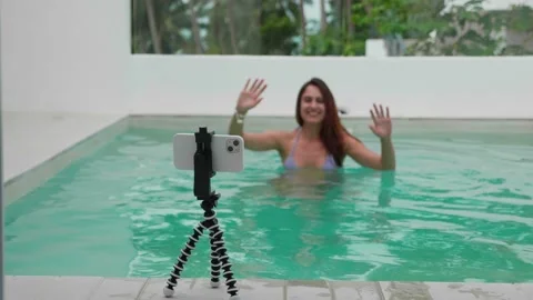 Video chat from the swimming pool. Focus on phone. Blurred girl silhouette Video stock 205893693
