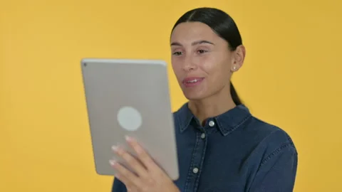 Video Chat on Tablet by Young Latin Woman, Yellow Background 스톡 동영상 141680163