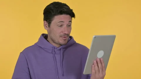Video Chat on Tablet by Young Man, Yellow Background Stockbeeldmateriaal 141684437