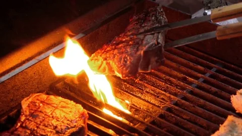 Video of checking steaks on the grill in real slow motion Stock Footage