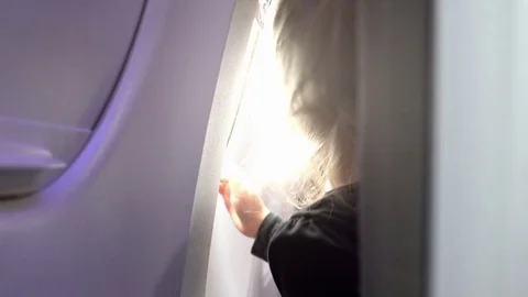 Video of child looking through the airplane window in real slow motion Stock Footage 77443003
