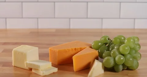 Video clip of hand placing cheese and bread onto food tray picking a grape Stock Footage 125784909