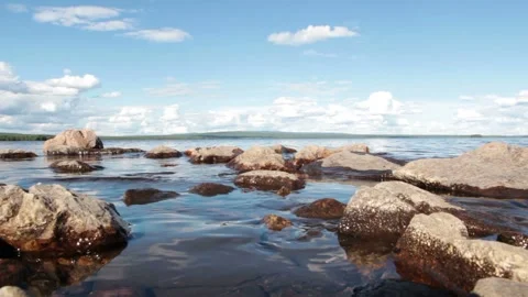 Video clip shows a closeup view of several rocks in water of a lakefront during Stock Footage 160829604