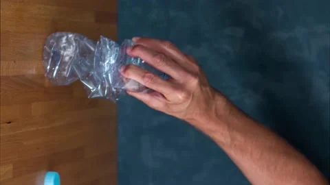 Video clip in vertical format of a hand crushing a plastic bottle. Recycling Stock Footage 143767724