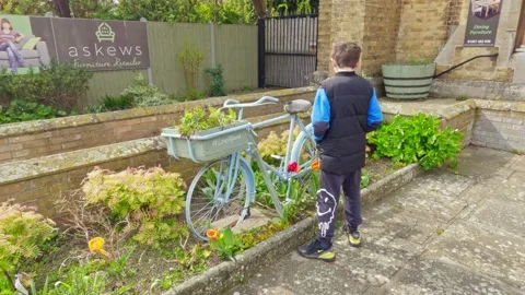 Video clip of a young boy looking at an old painted bicycle in the historic.. Stock-Footage 239638609