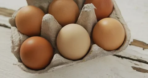 Video of close up of brown eggs in egg carton on rustic background Stock Footage 340068197