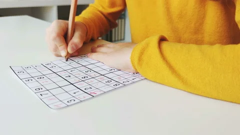 Video of close-up children's hands solving sudoku puzzle with a pencil as a h Stock Footage 132219612