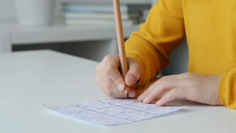 Video of close-up children's hands solving sudoku puzzle with a pencil as a h Stock Footage 133727526