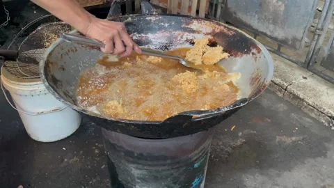 Video close-up deep frying coated chicken (fried chicken) in a large wok Stock Footage 322587451