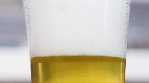 Video close up of the foam on top of a glass of beer with bubbles. Stock Footage 344035053