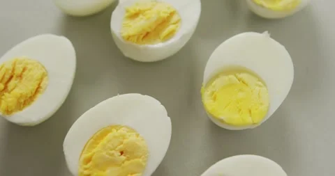 Video of close up of halves of hard boiled eggs on grey background Stock Footage 339650543