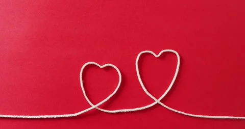 Video of close up of hearts of string on red background Stock Footage 331245869