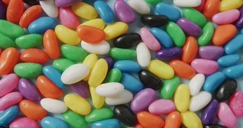 Video of close up of multi coloured sweets over blue background Stock Footage 338059263