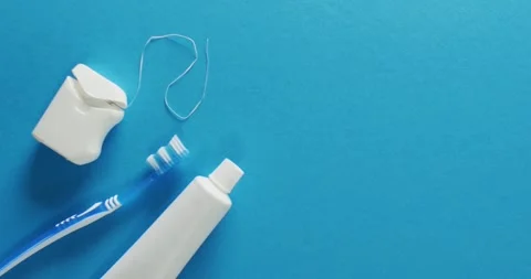 Video of close up of toothbrush, paste and floss on blue background Stock Footage 331294731