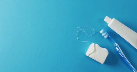 Video of close up of toothbrush, paste and floss on blue background Stock Footage 331358550