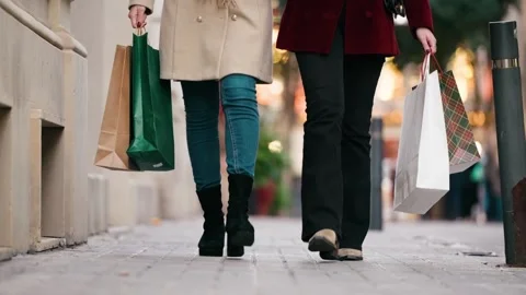 Video of close up of two friends walking on the city street with shopping bag Stock Footage 340825397