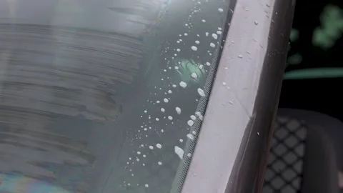 Video close up of windshield wipers moving washer fluid away. Stock Footage 341681717