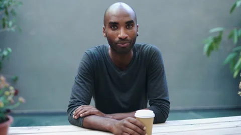 Video of confident man drinking a cup of coffe while doing a videocall sitt.. Stock Footage 237692049