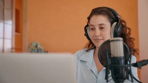 Video content creator or podcast host engages with fans over computer and mic Stock Footage 218474855