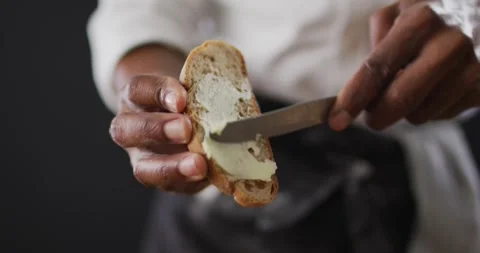 Video of cook grease bread with butter on black background Stock Footage 336436015
