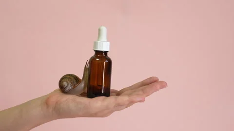 Video. Cosmetic bottle with snail on it in hand. Spa, naturale, luxury, Stock Footage 342396256