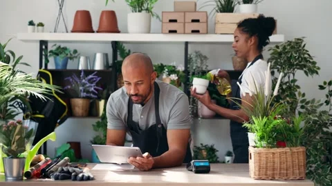 Video of couple of florists using a digital tablet while watering plants an.. 库存影片 330290923