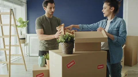 Video of couple packing things to boxes while moving house Stock-Footage 131705479