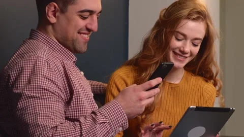 Video. Couple spending the weekend looking for tickets on the phone and tablet Stock Footage 162790601