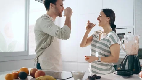 Video of cute couple drinking some detox juice together in the kitchen at hom Video stock 280172826