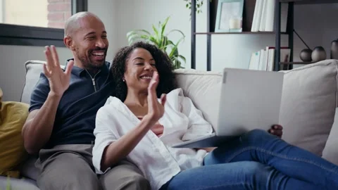 Video of cute couple using computer while lying on the couch at home. Stock Footage 328186775