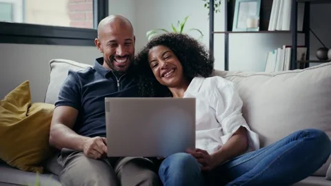 Video of cute couple using computer while sitting on the couch at home. Stock Footage 328186788