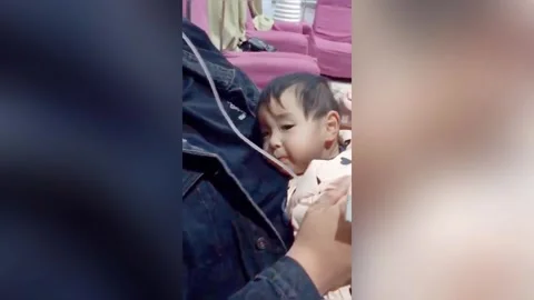 Video of dad placing IV drip in his mouth to warm it for his sick baby daughter Stock Footage 272893738