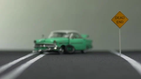 Video of a destroyed, light blue, retro car figurine left in the middle of a  Stock Footage 133491568