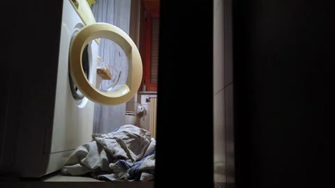 Video of dirty laundry on the floor in front of the washing machine Stock Footage 220747966