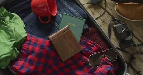 Video of documents, glasses, camera, mug and clothes prepared to be packed in Stock Footage 336608594