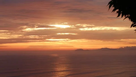 Video of a dramatic sunset over the ocean with storm clouds in the sky. Stock Footage 236274816