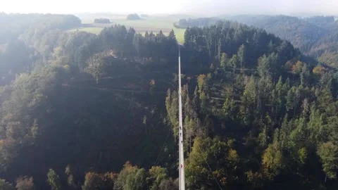 Video from a drone flying over a suspended wooden bridge over a dense forest. Stock Footage 163656957