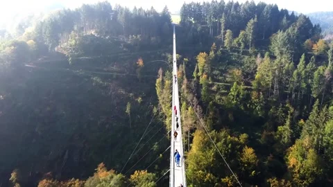 Video from a drone flying over a suspended wooden bridge with steel ropes. Stock Footage 163670607